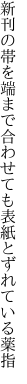 新刊の帯を端まで合わせても 表紙とずれている薬指