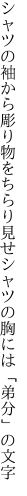 シャツの袖から彫り物をちらり見せ シャツの胸には「弟分」の文字